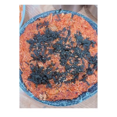 김치 볶음밥 위에 곤약김과 참깨가 뿌려진 모습이 담긴 접시.